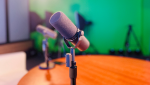 two podcasting microphones sitting on a table in a podcast studio