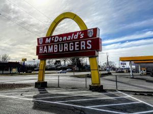 mcdonalds golden arches logo in an empty parking lot.