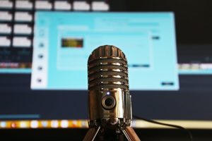 podcast microphone in front of a computer screen