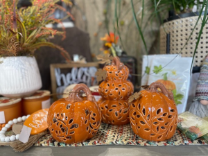 several orange carved pumpkins sitting on a wooden shelf at a gift store in omaha