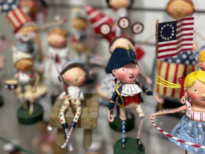Dozens of small lori mitchell figurines sitting on a shelf at a gift shop in omaha
