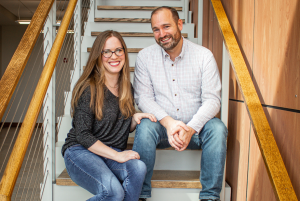 a business woman and a business man sitting on a staircase in a consulting business.