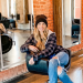 a women with jeans and a flannel siting in a salon chair