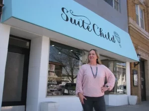 a female business owner standing outside her children's boutique