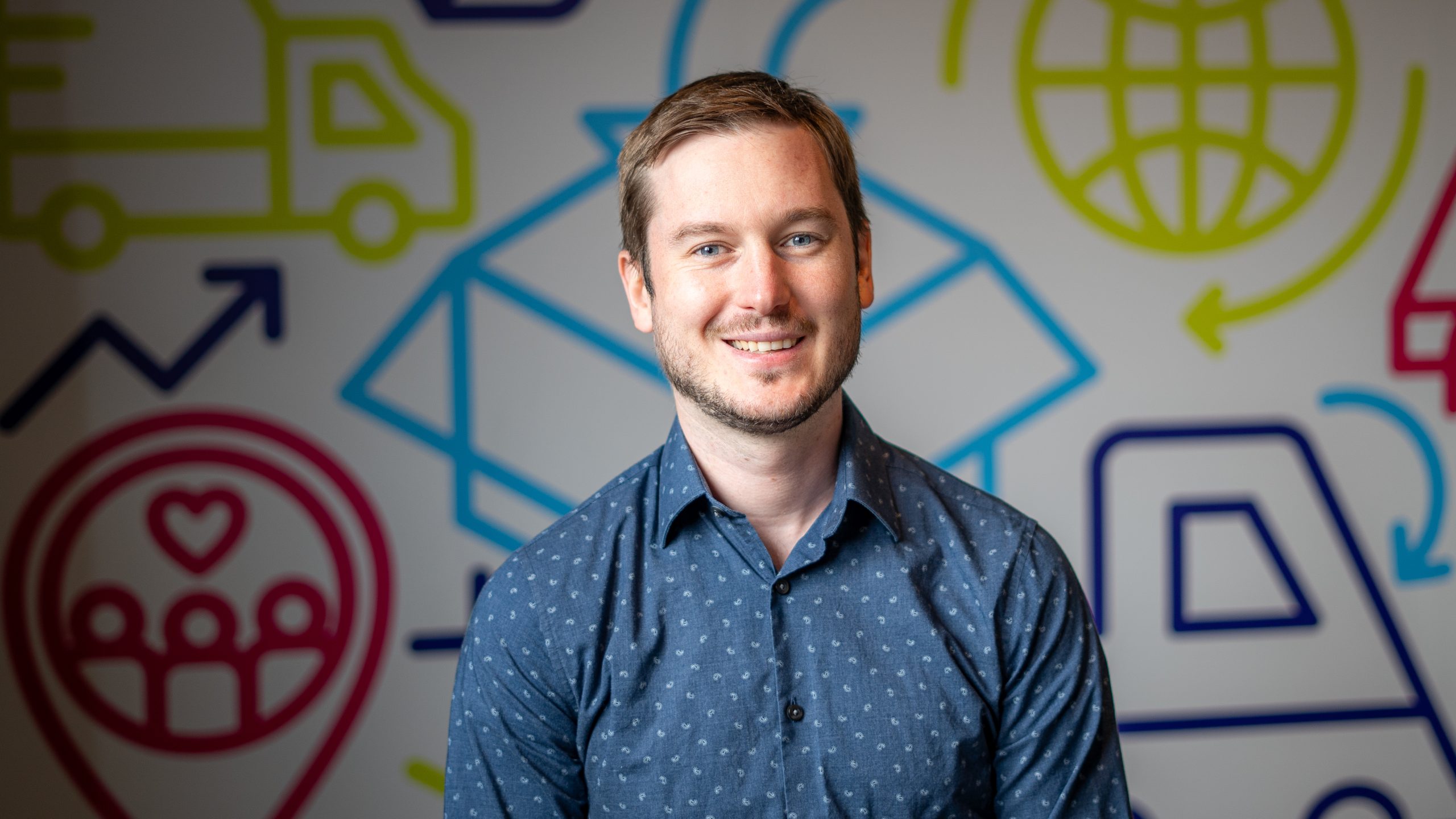 a young man with a blue shirt posing for a headshot a young man with a blue shirt posing for a headshot