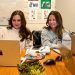 two women sitting at a table with their laptops