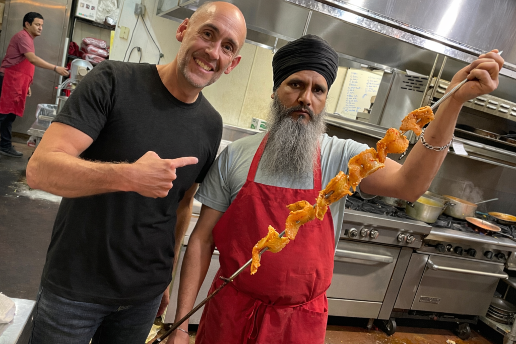 Hospitality marketing consultant working alongside a restaurant cook inside a commercial kitchen
